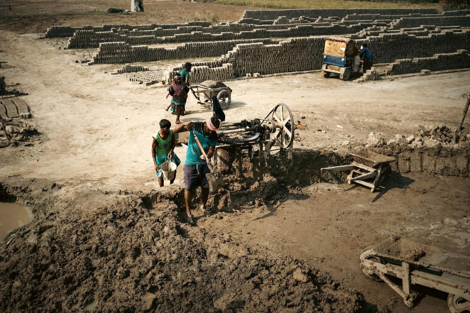 Människor arbetar i ett tegelfält, ett exempel på de komplexa ekonomiska realiteterna.