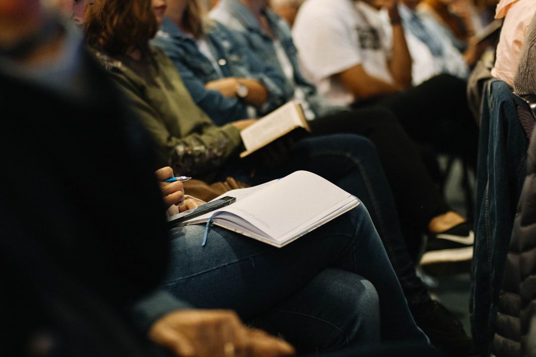 En publik som antecknar under ett informationsmöte eller seminarium.